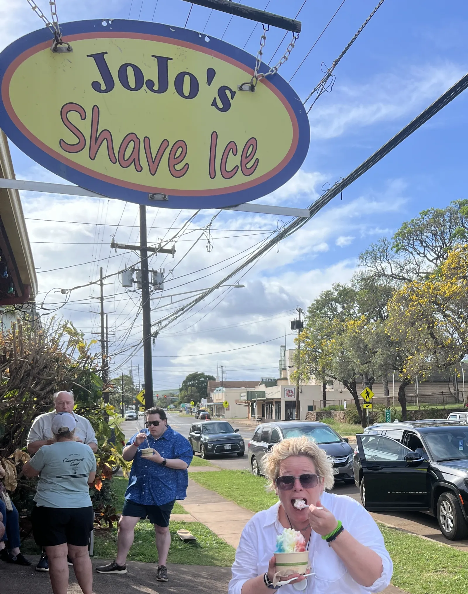 Katrin isst Shave Ice vor dem Schild von JoJo’s Shave Ice auf Hawaii